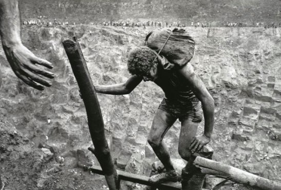 A miner carries his load to the top of the Serra Pelada gold mine, Brazil. Image (c) Sebastiao Salgado.