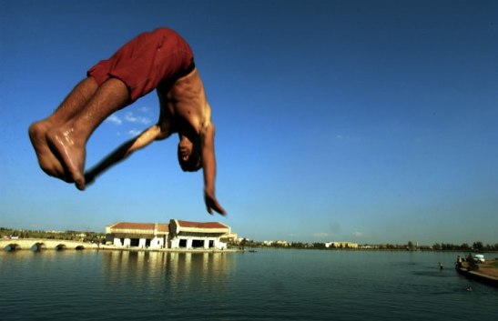 A boy dives into the water at a former palace of Saddam Hussein, Mosel, Iraq, 2003. Lynsey Addario/Getty Images Reportage